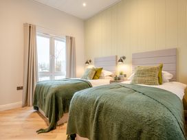 A bedroom with two beds and a window at Trelowen 4.0 Spa Marhamchurch