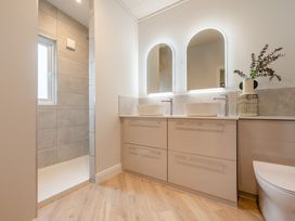 A bathroom with dual sinks and a shower at Trelowen 4.0 Spa in Marhamchurch