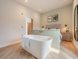A bedroom with a bathtub and a bed at Trelowen 4.0 Spa in Marhamchurch