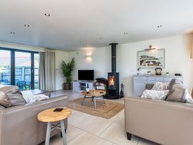 A living room with a fireplace and television at Arundell in Marhamchurch