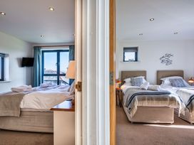 A bedroom with two beds and a television at Arundell in Marhamchurch