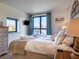 A bedroom with a bed and window at Arundell in Marhamchurch