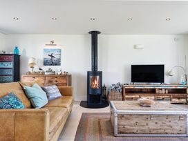 A living room with a fireplace and sofa at Eagle's Nest in Marhamchurch