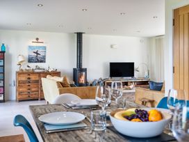A living room with a fireplace and seating area at Eagle's Nest in Marhamchurch