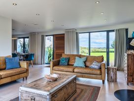 A living room with a sofa and dining area at Eagle's Nest in Marhamchurch