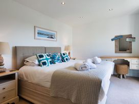 A bedroom with a bed and a desk at Eagle's Nest in Marhamchurch