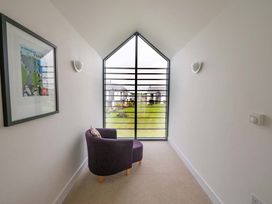 A hallway with artwork and a chair at Medlands in Marhamchurch