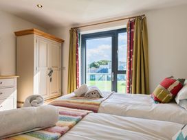 A bedroom with two single beds and a wardrobe at Moleyns in Marhamchurch