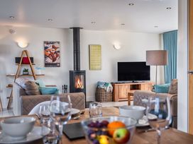 A living room with a sofa, TV, and fireplace at Sheep's House in Marhamchurch