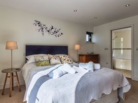 A bedroom with a bed and bathroom door at Sheep's House in Marhamchurch