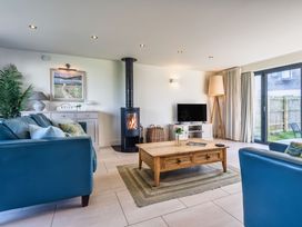 A living room with a coffee table and wood stove at Trevelyan in Marhamchurch