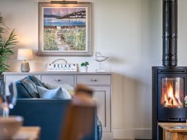 A living room with a sofa and a wood stove at Trevelyan in Marhamchurch