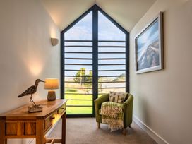 A hallway with a table and an armchair at Trevelyan in Marhamchurch