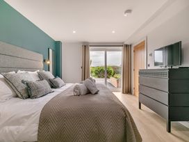 A bedroom with a bed and a television at Gwari Spa Barn 3.0 Marhamchurch