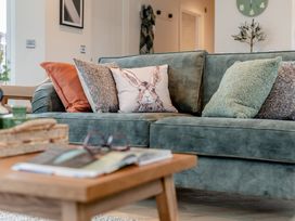 A living room with a green sofa and coffee table at Trelowen 3.0 Spa Marhamchurch