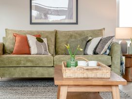A living room with a green sofa and coffee table at Trelowen 3.0 Spa in Marhamchurch