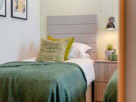 A bedroom with a bed and bedside table at Trelowen 3.0 Spa in Marhamchurch