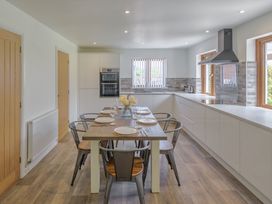 A kitchen with dining table and chairs at Windy Hills Spa in Marhamchurch