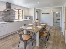 A dining room with a wooden table and chairs at Windy Hills Spa Marhamchurch