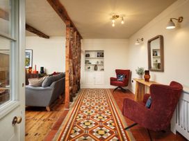A living room with a sofa and chairs at Whalesborough Farmhouse Spa in Marhamchurch