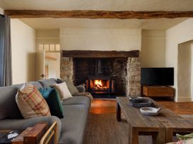 A living room with a fireplace and sofa at Whalesborough Farmhouse Spa Marhamchurch