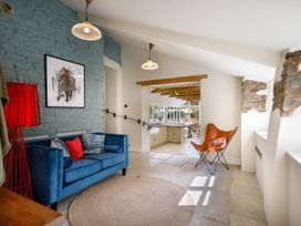 A living room with a sofa and artwork at Whalesborough Farmhouse Spa in Marhamchurch