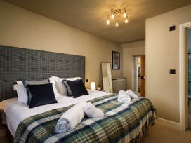 A bedroom with a bed and mirror at Whalesborough Farmhouse Spa Marhamchurch