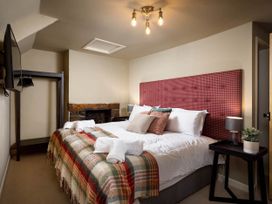 A bedroom with a bed and TV at Whalesborough Farmhouse Spa in Marhamchurch