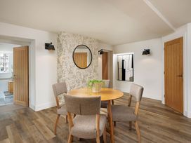 A dining room with a round table and chairs at Whalesborough Cottage Spa in Marhamchurch