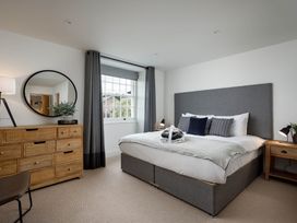 A bedroom with bed and dresser at Whalesborough Cottage Spa in Marhamchurch