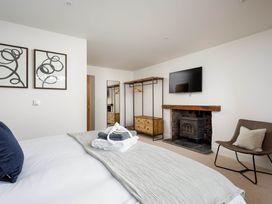 A bedroom with a bed, TV, and fireplace at Whalesborough Cottage Spa in Marhamchurch