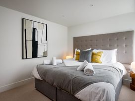 A bedroom with a bed and artwork at Whalesborough Cottage Spa in Marhamchurch