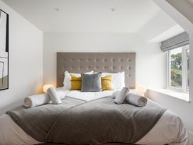 A bedroom with a bed and artwork at Whalesborough Cottage Spa in Marhamchurch