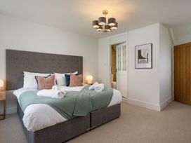 A bedroom with a bed and lamp at Whalesborough Cottage Spa in Marhamchurch