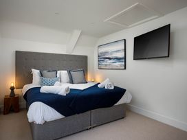 A bedroom with a bed and television at Whalesborough Cottage Spa in Marhamchurch