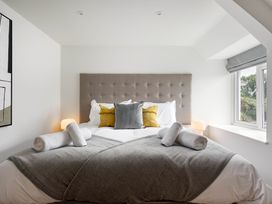 A bedroom with a bed and pillows at Whalesborough Cottage Spa Marhamchurch