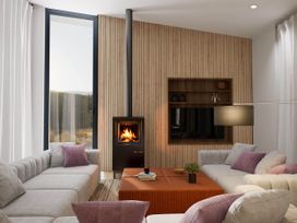 A living room with a fireplace and sofa at Kew Villa (Pet) Marhamchurch