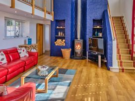 A living room with a fireplace and television at Calf House Spa Marhamchurch