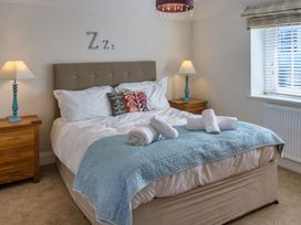 A bedroom with a bed and nightstands at Calf House Spa Marhamchurch
