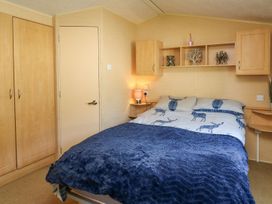 A bedroom with a bed and wardrobe at Caravan 2 at Blackmoor Farm near tenby