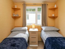 A bedroom with two beds and a nightstand at Caravan 2 at Blackmoor Farm near tenby