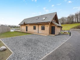 A log cabin with a gravel area and a wooden table at Tranquillity 4 in Carnforth