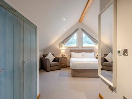 A bedroom with a bed and armchairs at Tranquillity 4 in Carnforth