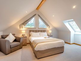 A bedroom with a bed and armchair at Tranquillity 4 in Carnforth