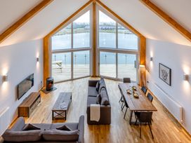 A living room with a sofa, dining table, and large windows at Tranquillity 4 (Pet) in Carnforth