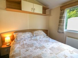 A bedroom with a bed and a window at Caravan 3 at Blackmoor Farm near tenby