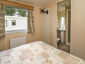 A bedroom with a bed and an adjoining bathroom at Caravan 3 at Blackmoor Farm near tenby