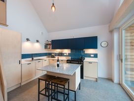 A kitchen with a central island and stools at The Telfer in North Berwick
