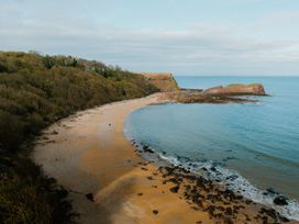 A beach with water and rocks at The Telfer in North Berwick