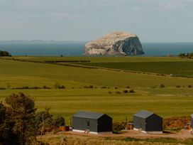 A view of an island and huts in a field at The Irvine in North Berwick